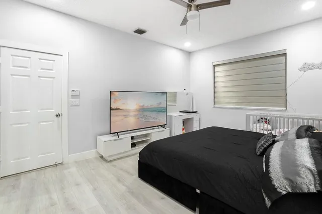 a bedroom with a bed and large windows