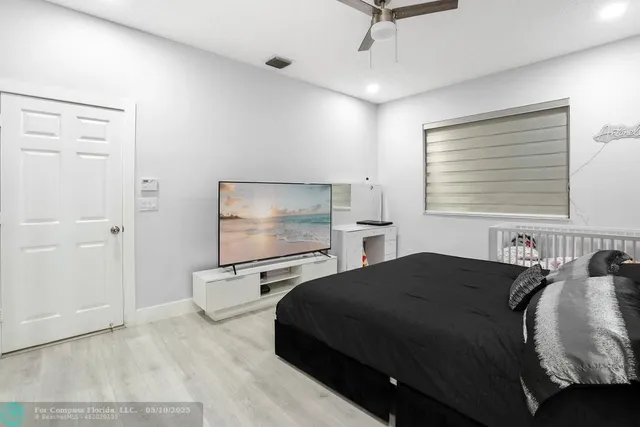 a bedroom with a bed and large windows