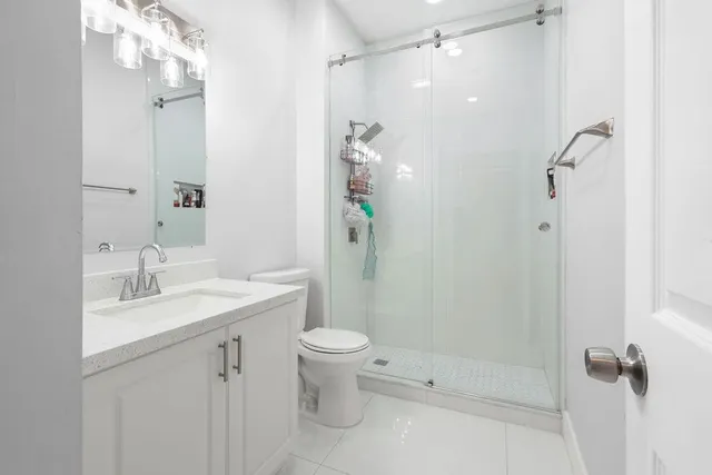 a bathroom with a sink a toilet and shower