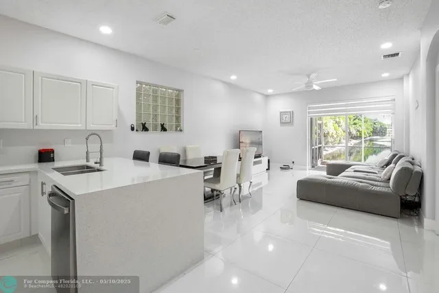 a living room with furniture a window and a view of kitchen