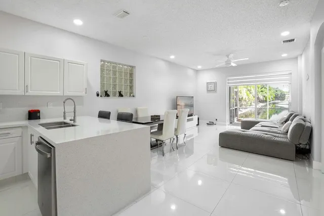 a living room with furniture a window and a view of kitchen