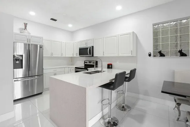 a kitchen with stainless steel appliances a refrigerator stove microwave and sink