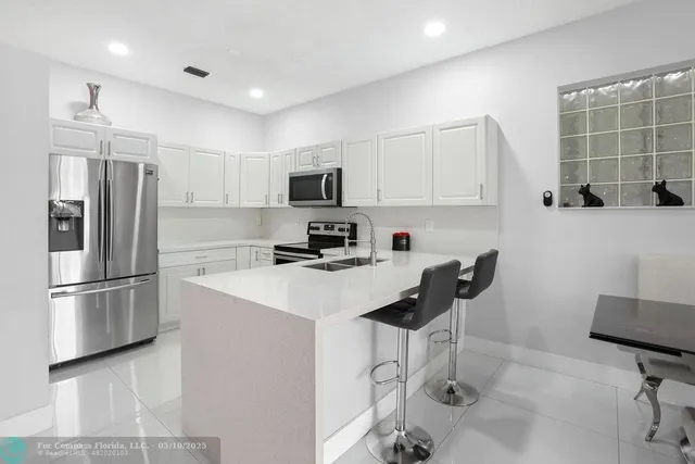 a kitchen with stainless steel appliances a refrigerator stove microwave and sink