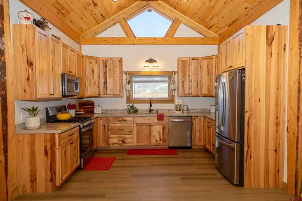 a kitchen with stainless steel appliances granite countertop a refrigerator a stove and a sink
