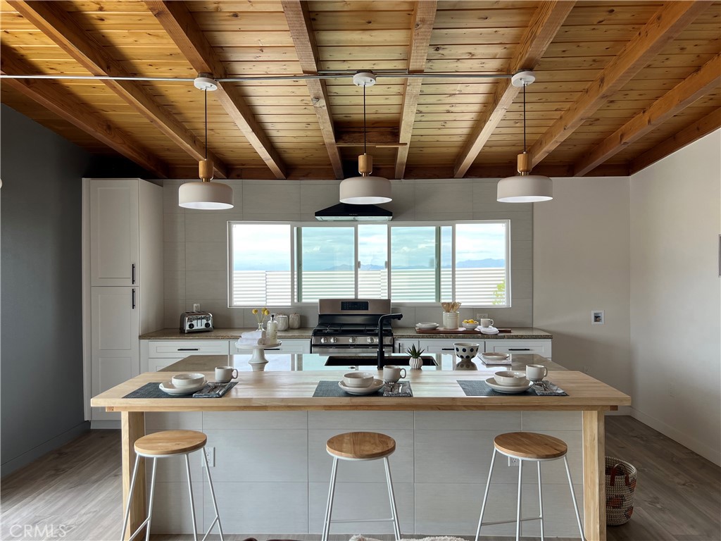 a kitchen with stainless steel appliances granite countertop a sink a stove and a refrigerator