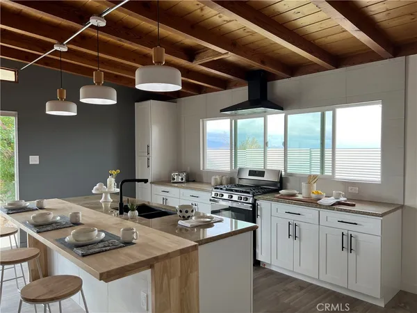 a kitchen with stainless steel appliances granite countertop a sink a stove and wooden cabinets