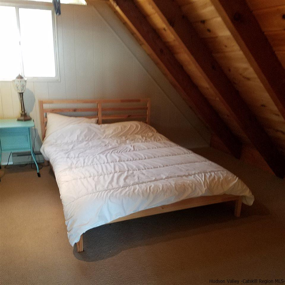 178 Upper Highland Circle Roxbury, NY 12421 - Photo 12 of 35 a bed sitting in a bedroom next to a window