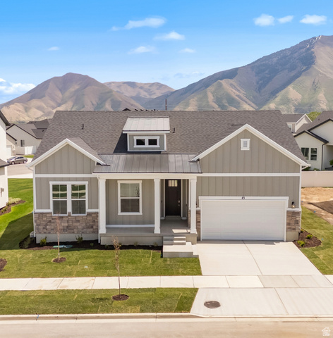 43 South Crimson Way, Unit 311 Mapleton, UT 84664 - Photo 1 of 28 Contemporary single-story residence with a gray siding and stone facade, featuring a dark asphalt shingle roof