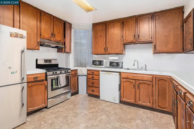 a kitchen with stainless steel appliances granite countertop a sink dishwasher stove and cabinets