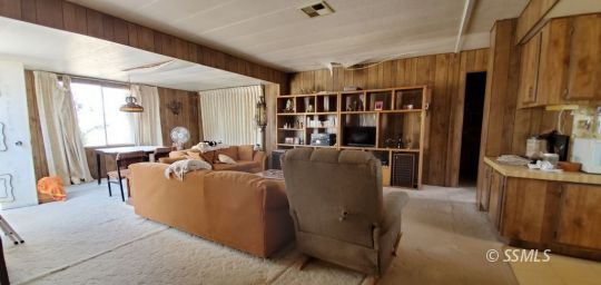720 North Calvert Boulevard Ridgecrest, CA 93555 - Photo 6 of 24 a living room with furniture a large window and wooden floor