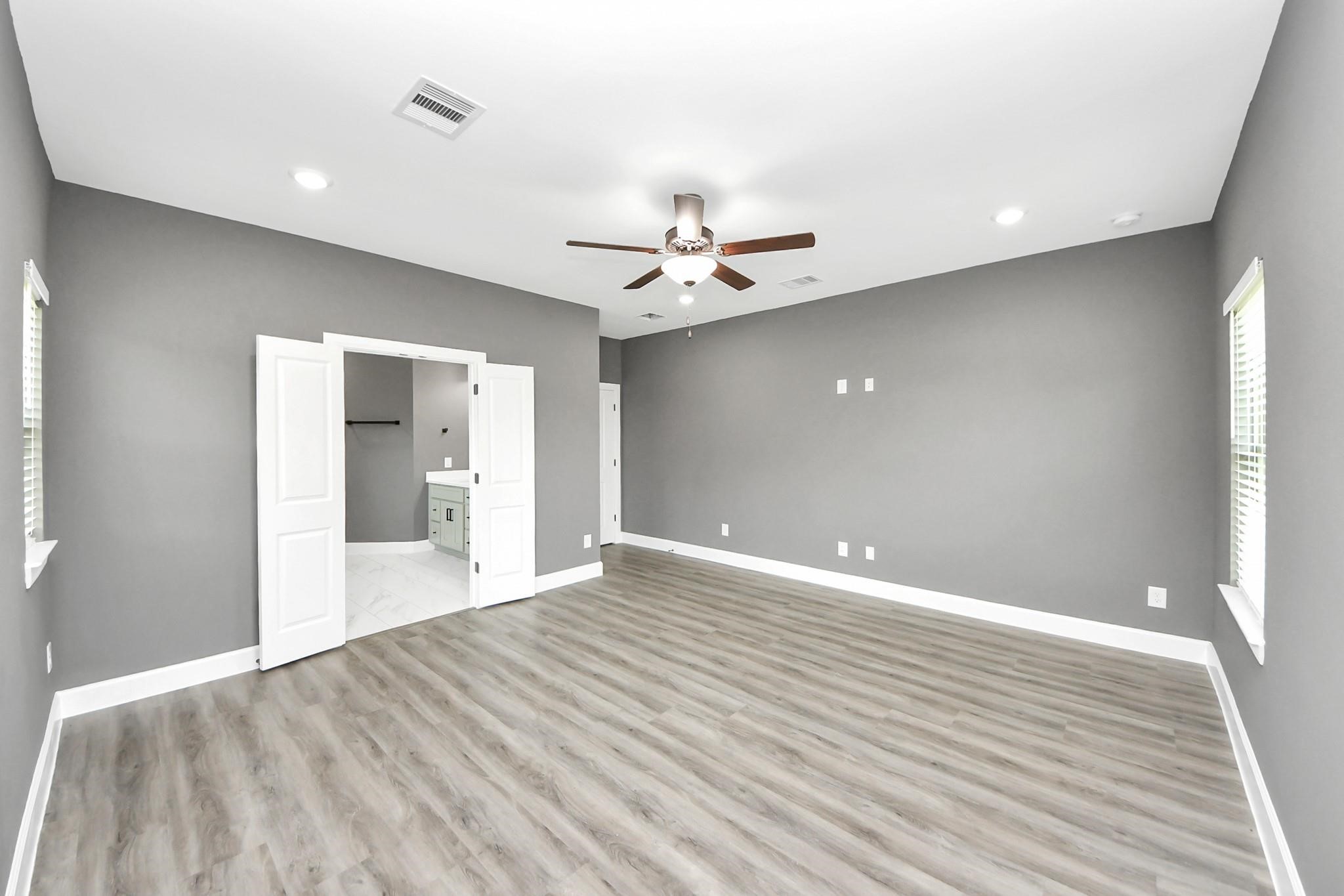 601 Lily Street Prairie View, TX 77484 - Photo 8 of 14 a view of an empty room with wooden floor and a ceiling fan