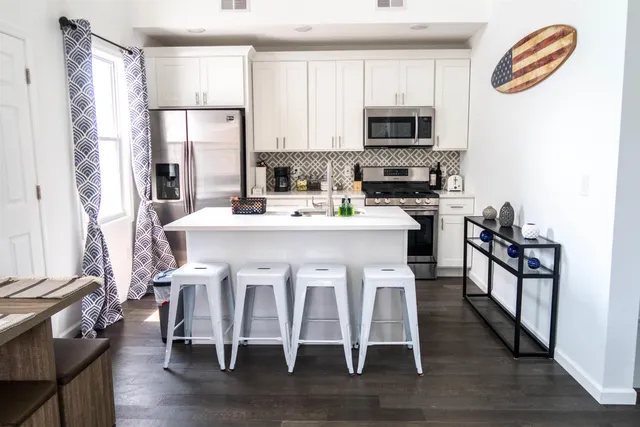 a kitchen with a table chairs refrigerator and microwave
