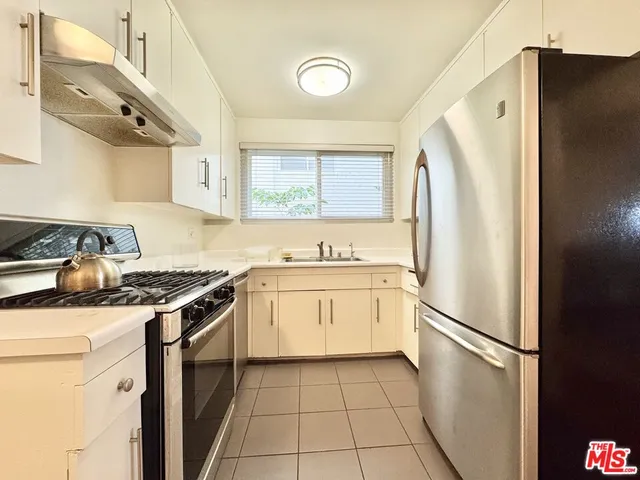 a kitchen with a stove a refrigerator and a sink