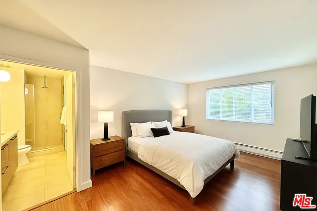 a bedroom with a bed and a flat screen tv