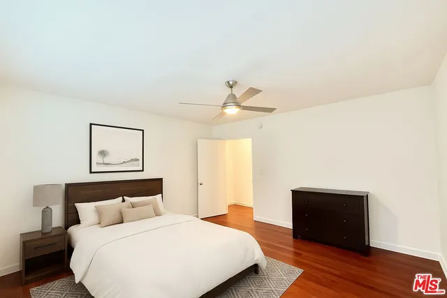 a bedroom with a bed and a ceiling fan
