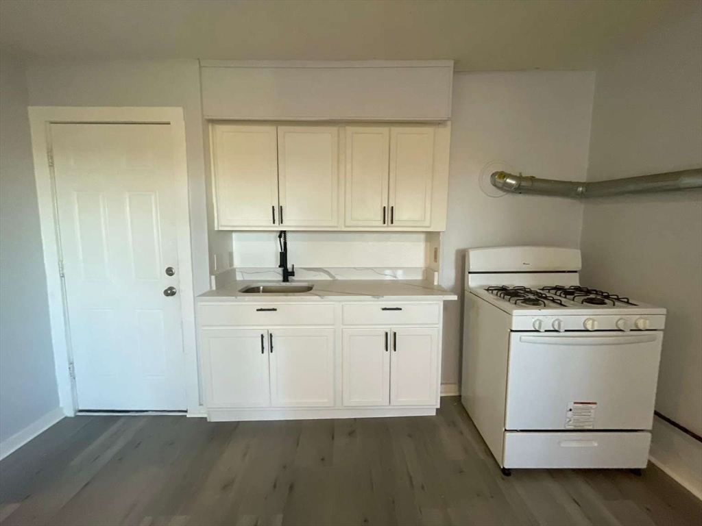 573 Main Street Southbridge, MA 01550 - Photo 7 of 15 a kitchen with cabinets appliances and wooden floor