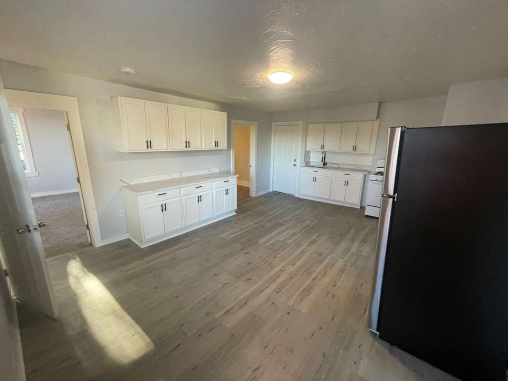 573 Main Street Southbridge, MA 01550 - Photo 8 of 15 a kitchen with a refrigerator stove and white cabinets