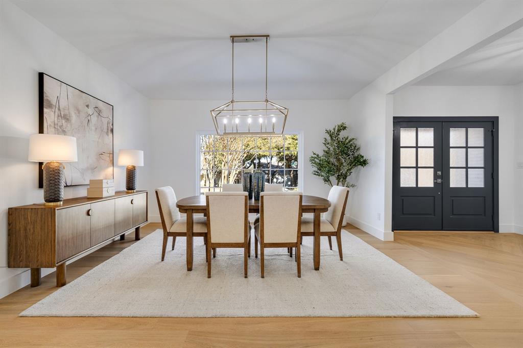 7124 Meadow Road Dallas, TX 75230 - Photo 12 of 39 a dining room with furniture a chandelier and wooden floor