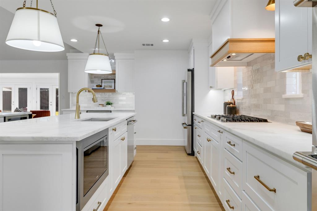 7124 Meadow Road Dallas, TX 75230 - Photo 14 of 39 a kitchen with granite countertop a sink a counter space appliances and cabinets