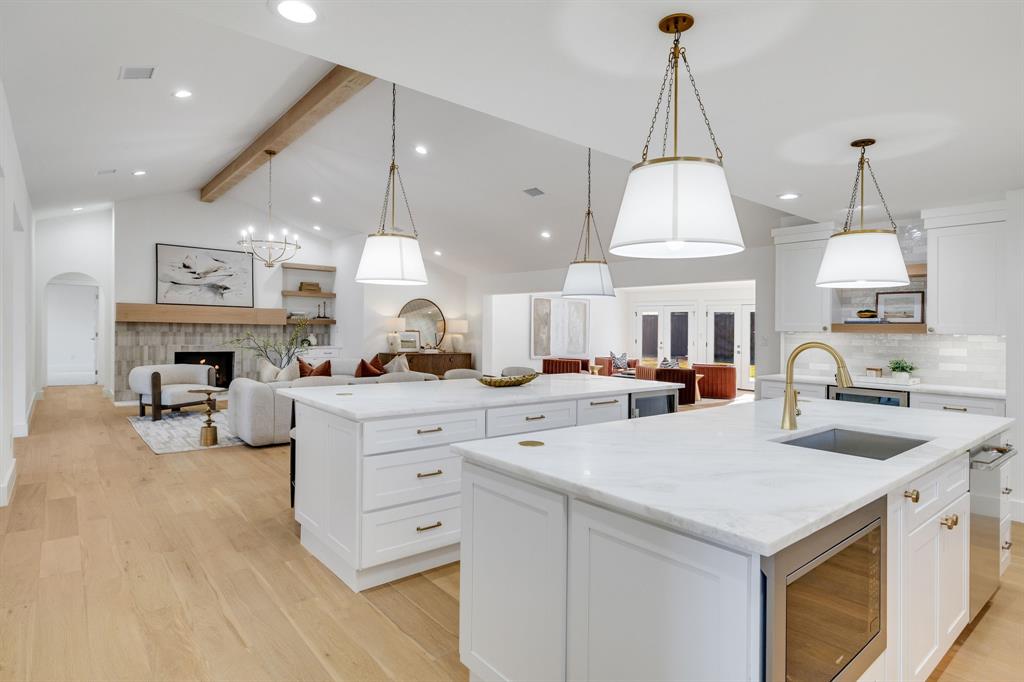 7124 Meadow Road Dallas, TX 75230 - Photo 15 of 39 a kitchen with stainless steel appliances granite countertop a sink a stove and a chandelier