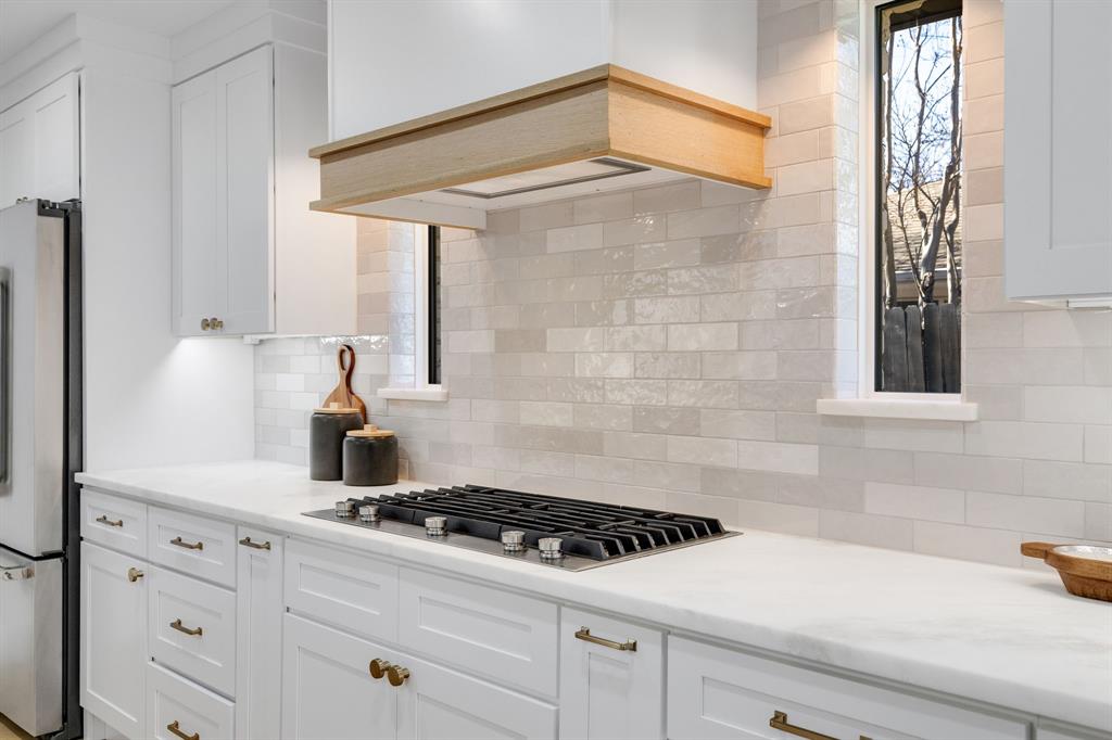 7124 Meadow Road Dallas, TX 75230 - Photo 17 of 39 a kitchen with a stove and white cabinets