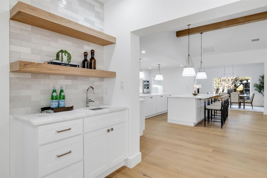 7124 Meadow Road Dallas, TX 75230 - Photo 21 of 39 a kitchen with kitchen island a sink cabinets and window