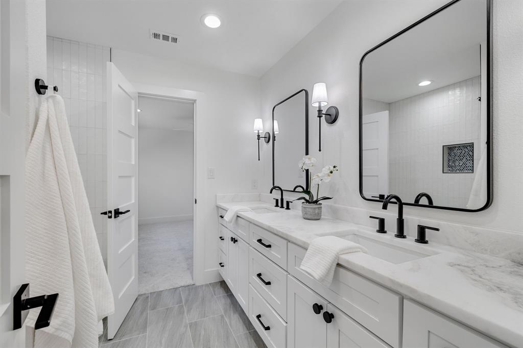 7124 Meadow Road Dallas, TX 75230 - Photo 25 of 39 a bathroom with double vanity sink and mirror