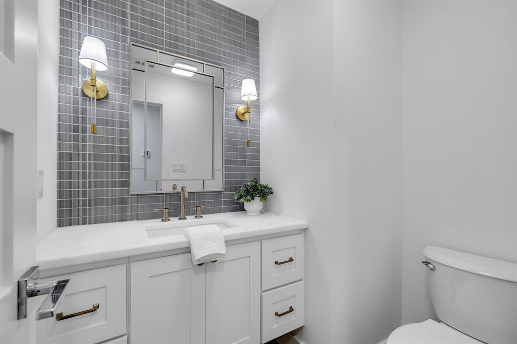 7124 Meadow Road Dallas, TX 75230 - Photo 27 of 39 a bathroom with a sink and mirror with toilet