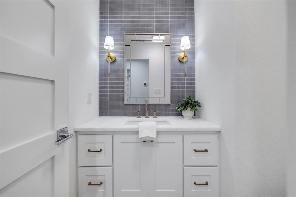 7124 Meadow Road Dallas, TX 75230 - Photo 28 of 39 a bathroom with a sink and a mirror