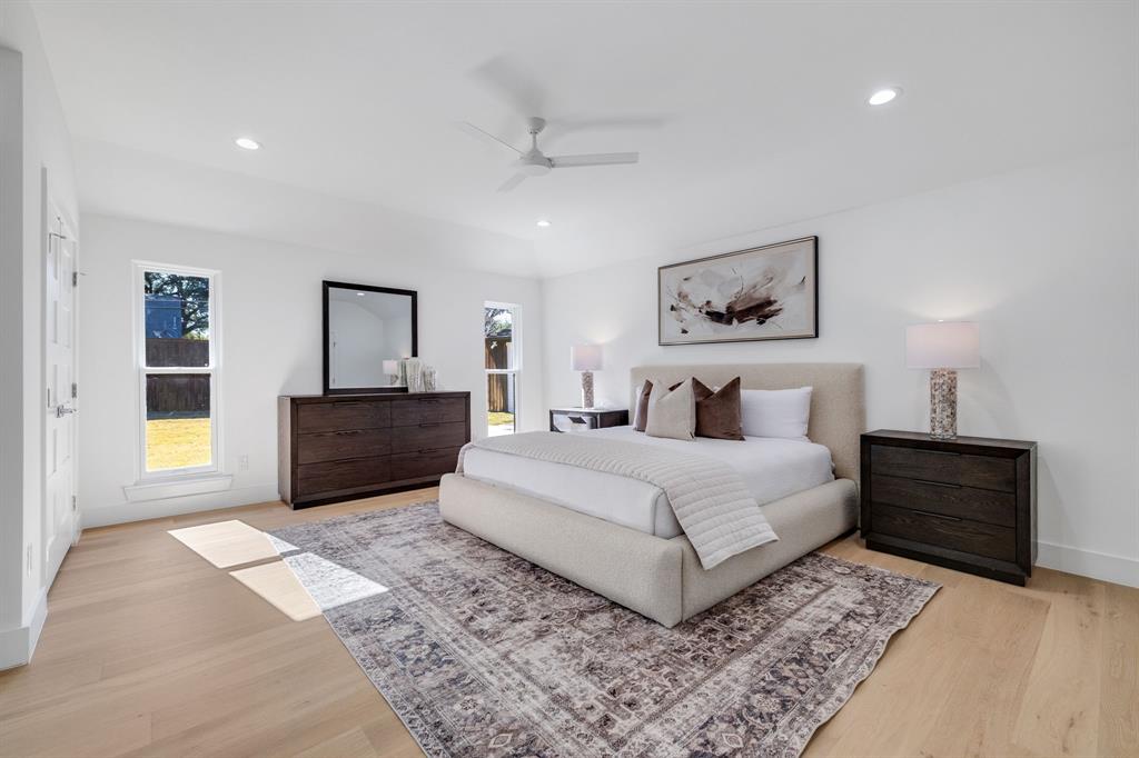 7124 Meadow Road Dallas, TX 75230 - Photo 29 of 39 a bedroom with a large bed and a painting on the wall