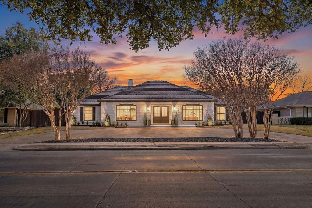 7124 Meadow Road Dallas, TX 75230 - Photo 3 of 39 a front view of a house with a garden