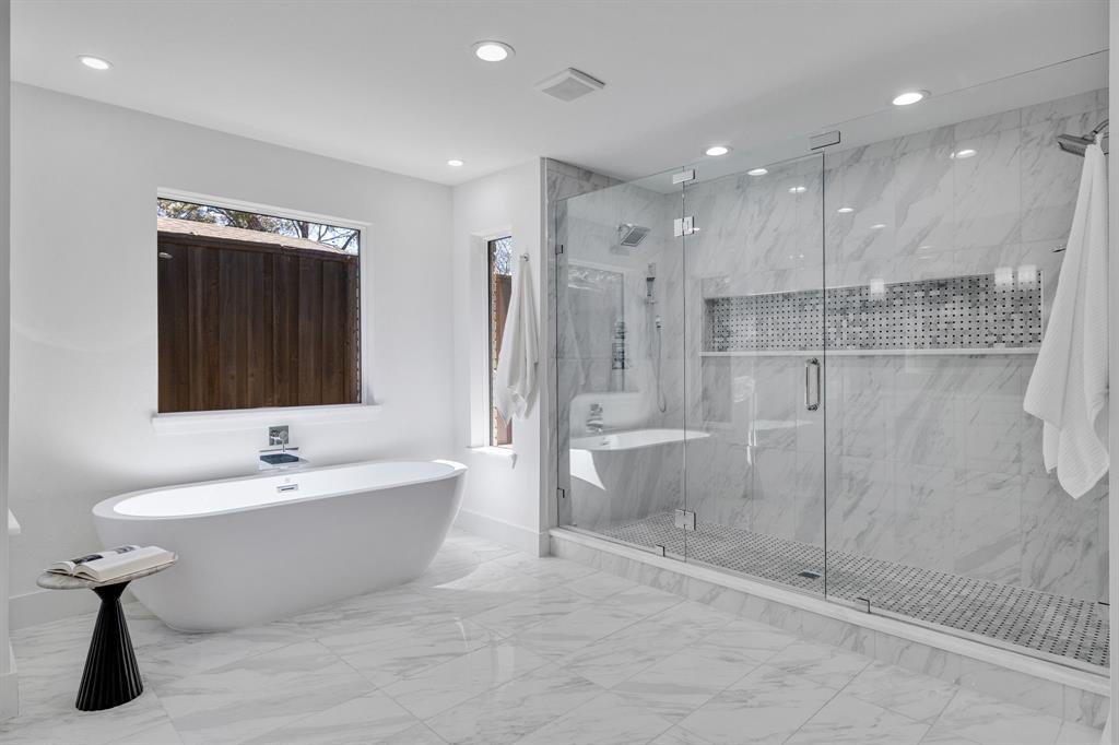 7124 Meadow Road Dallas, TX 75230 - Photo 31 of 39 a bathroom with a bathtub and a shower