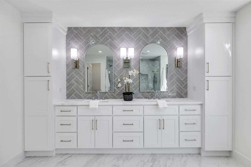 7124 Meadow Road Dallas, TX 75230 - Photo 33 of 39 a bathroom with a double vanity sink and a mirror