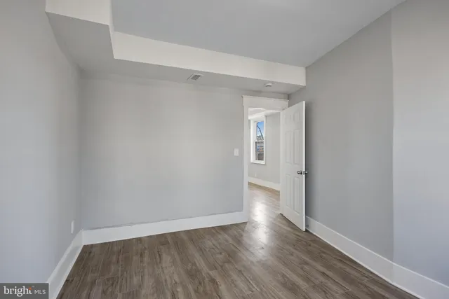 a view of an empty room with wooden floor