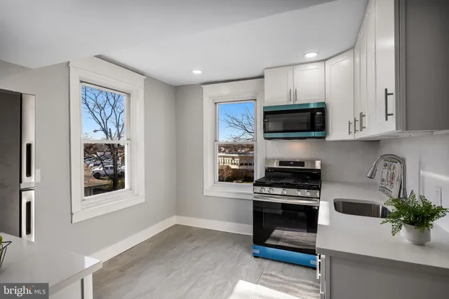 a kitchen with stainless steel appliances a stove microwave and sink