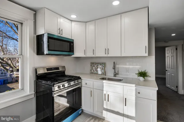 a kitchen with stainless steel appliances granite countertop white cabinets a stove top oven a sink and dishwasher