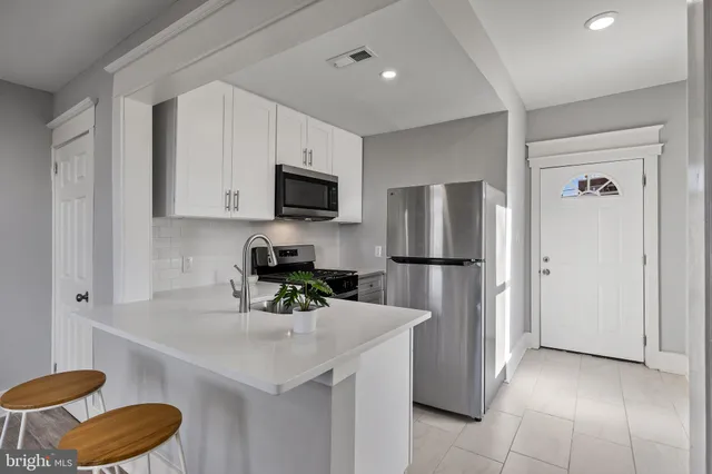 a kitchen with a refrigerator a microwave a sink and cabinets