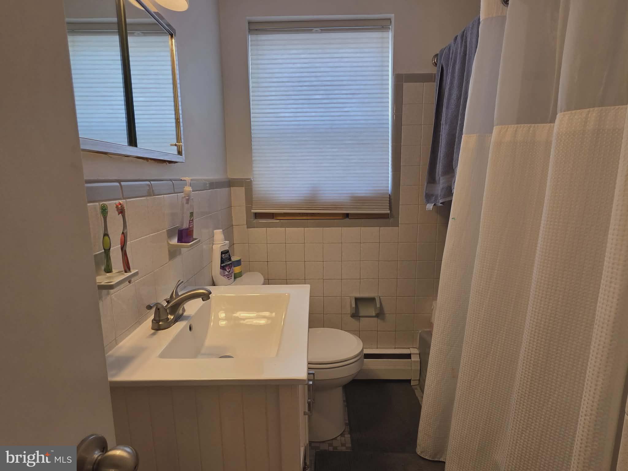 412 North Wayne Avenue, Unit 109 Wayne, PA 19087 - Photo 12 of 20 a bathroom with a sink a toilet and mirror