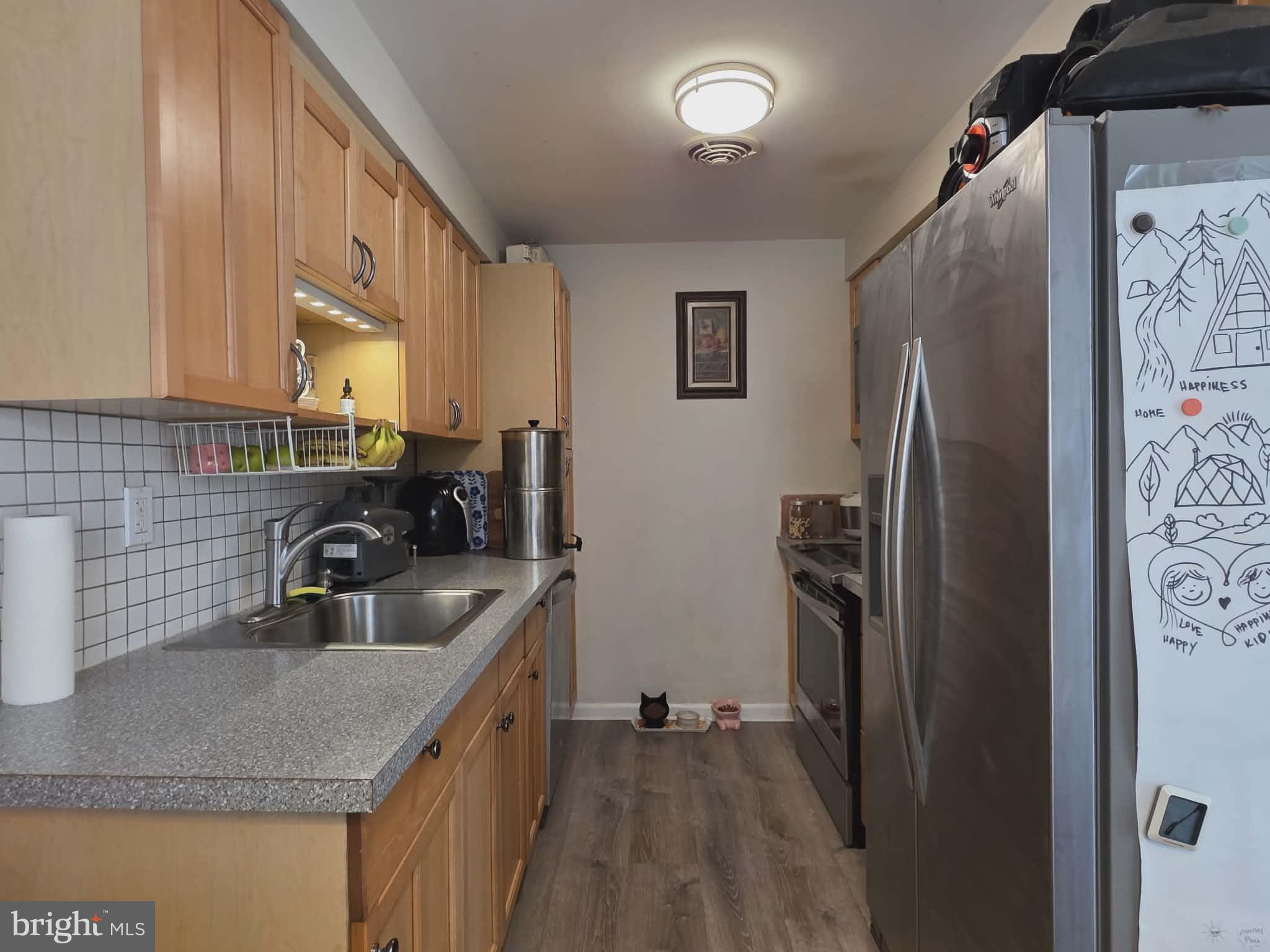412 North Wayne Avenue, Unit 109 Wayne, PA 19087 - Photo 6 of 20 a kitchen with stainless steel appliances granite countertop a refrigerator a sink a stove and a microwave oven