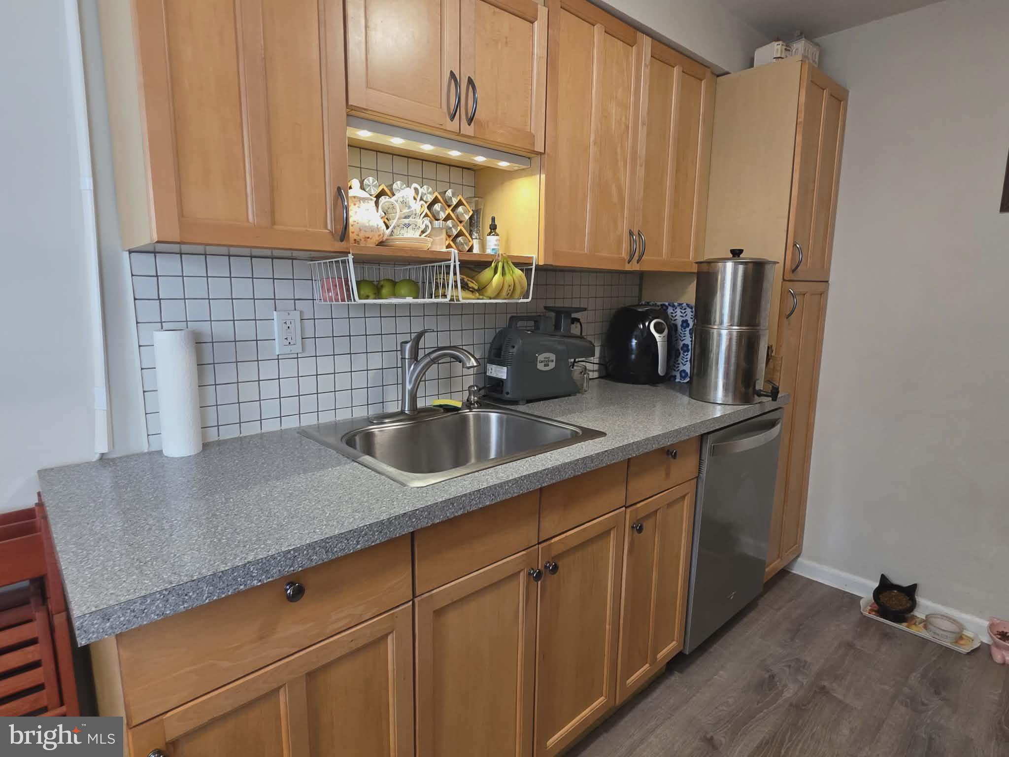 412 North Wayne Avenue, Unit 109 Wayne, PA 19087 - Photo 7 of 20 a kitchen with stainless steel appliances granite countertop a sink a stove and white cabinets