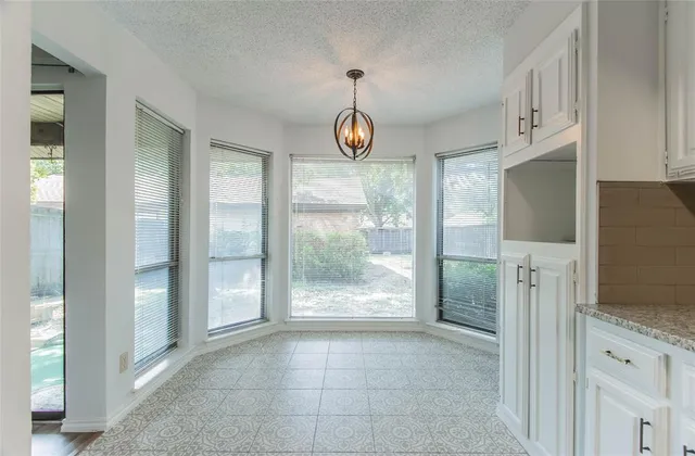 a very nice looking space with a large window and chandelier