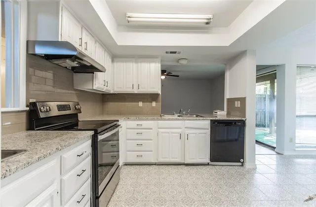 a kitchen with granite countertop a sink stainless steel appliances and cabinets