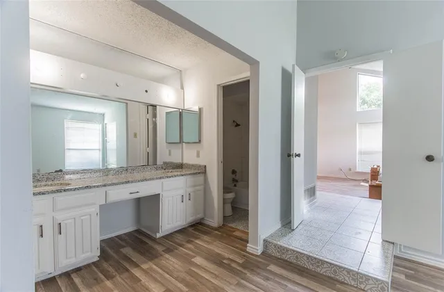 a spacious bathroom with a granite countertop sink mirror and a