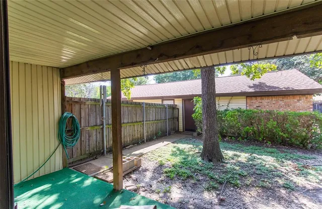 a view of a backyard with large trees and plants