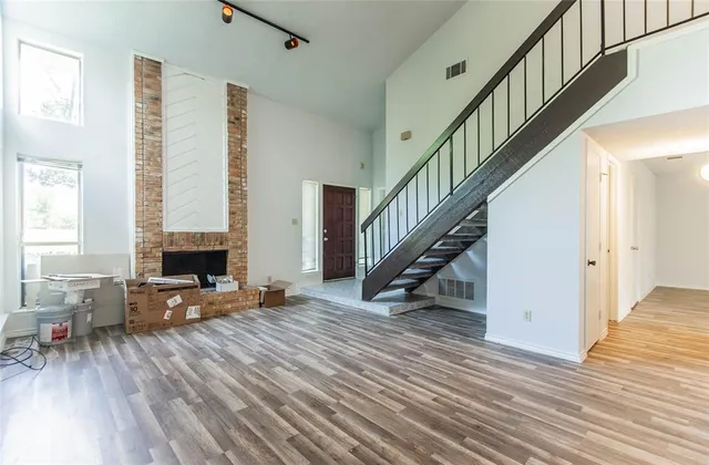 a view of a livingroom with furniture and stairs with wooden floor