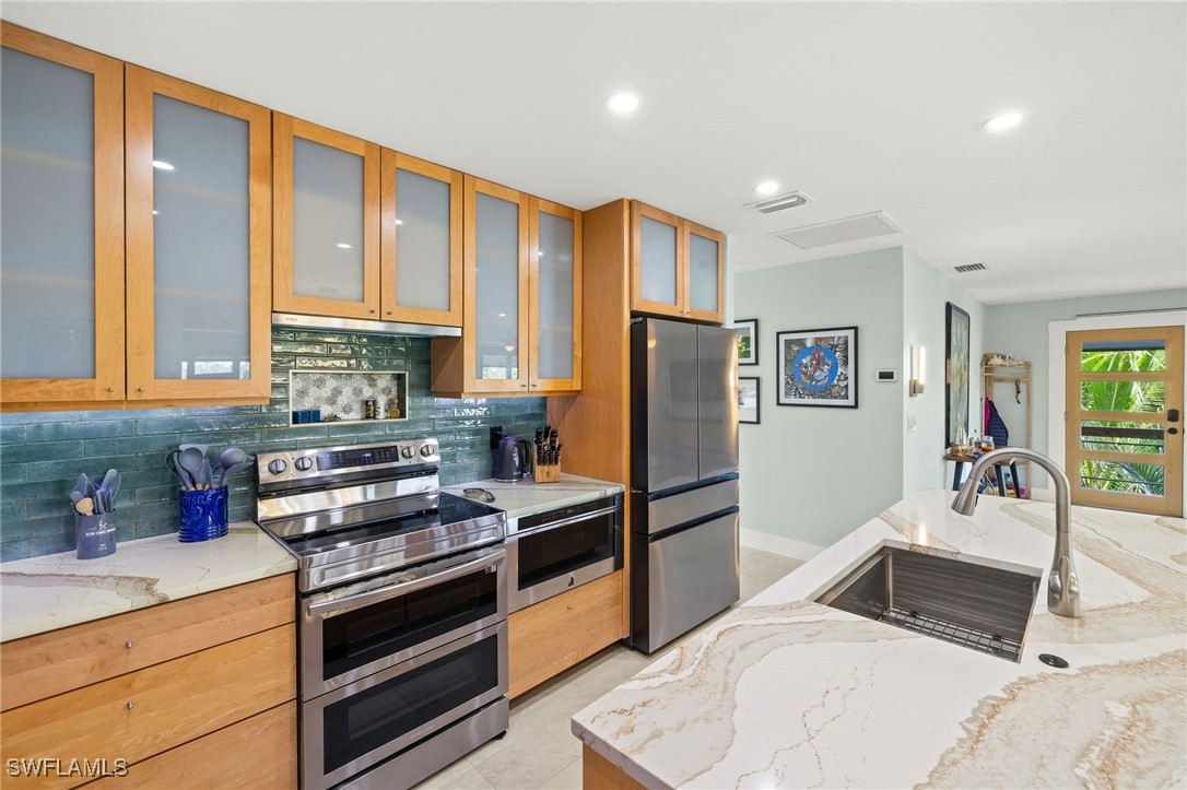 771 Rabbit Road Sanibel, FL 33957 - Photo 11 of 35 a kitchen with stainless steel appliances granite countertop a stove a sink and a refrigerator