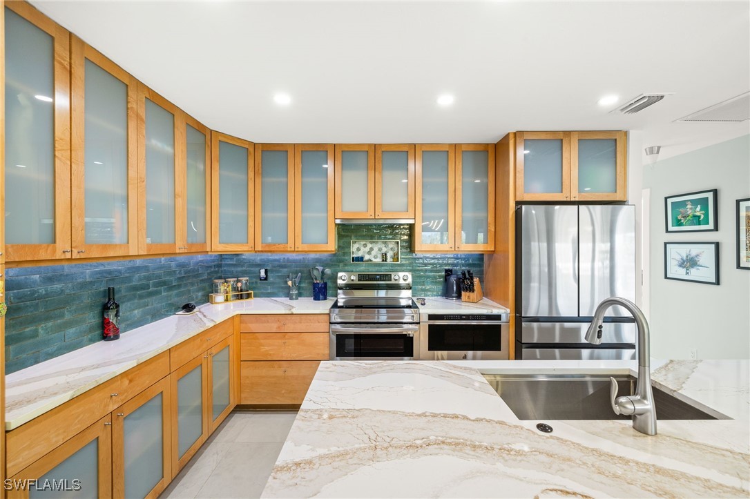 771 Rabbit Road Sanibel, FL 33957 - Photo 10 of 35 a kitchen with stainless steel appliances granite countertop a stove and a sink