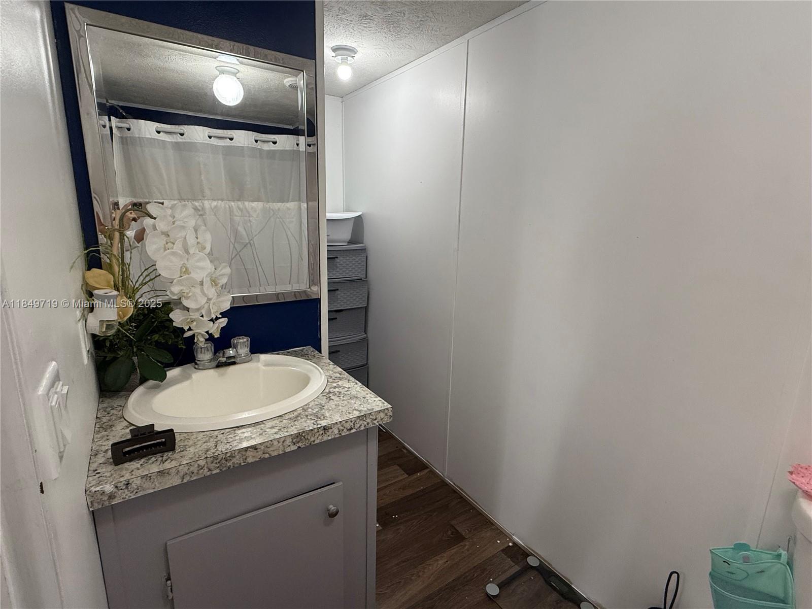 830 South Kennel Street Clewiston, FL 33440 - Photo 11 of 30 a bathroom with a granite countertop sink a toilet and a mirror