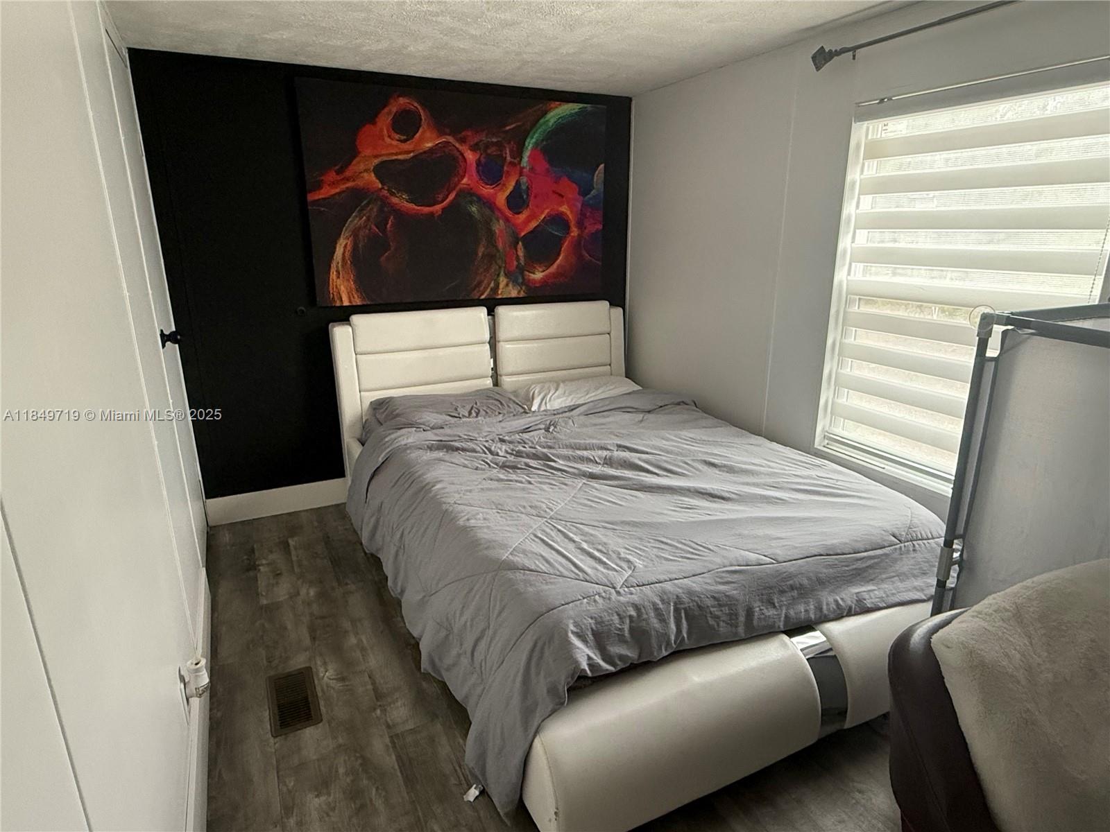 830 South Kennel Street Clewiston, FL 33440 - Photo 15 of 30 a bedroom with a bed and a painting on the wall