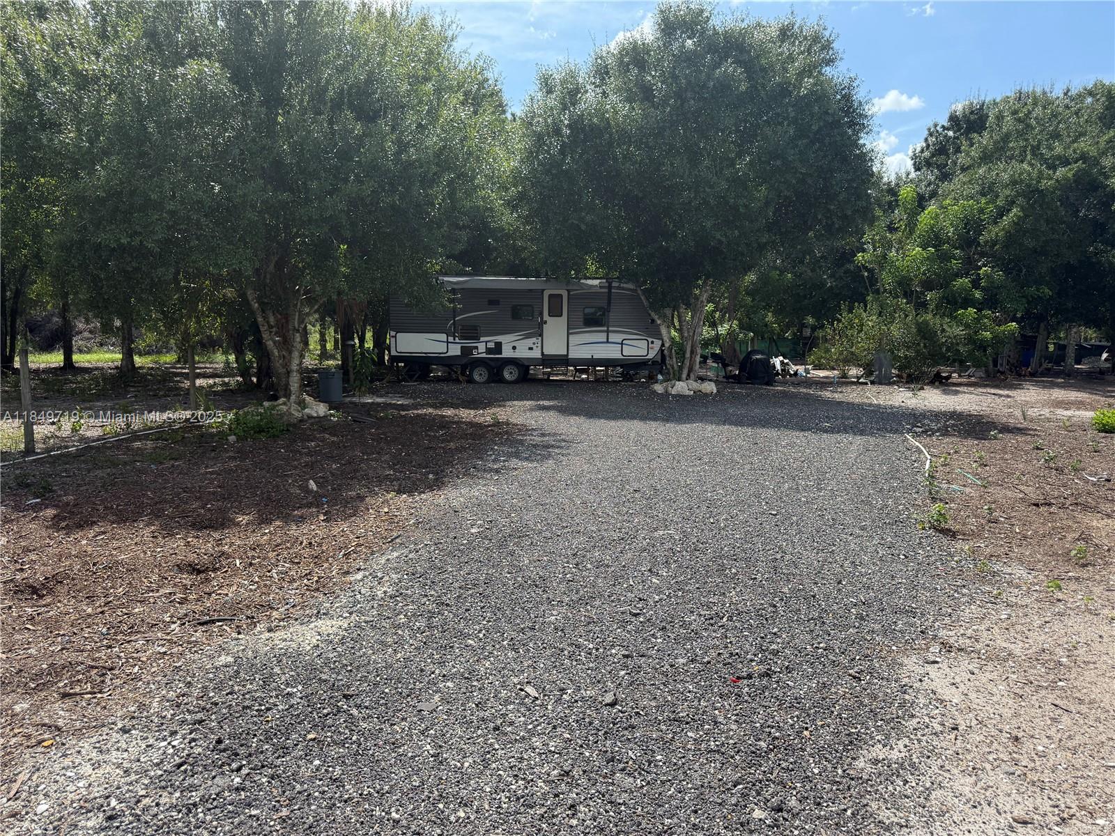 830 South Kennel Street Clewiston, FL 33440 - Photo 19 of 30 a view of a street with trees and bushes